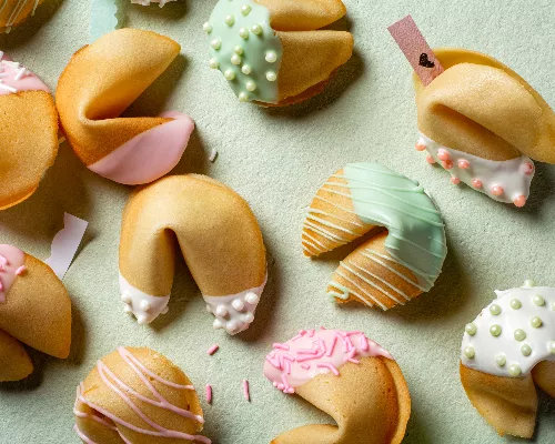 Fortune cookies dipped in icing and decorated with sprinkles