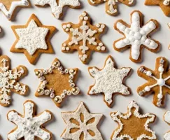 Rows of iced Gingerbread Spiced Cookies in snowflake and star shapes